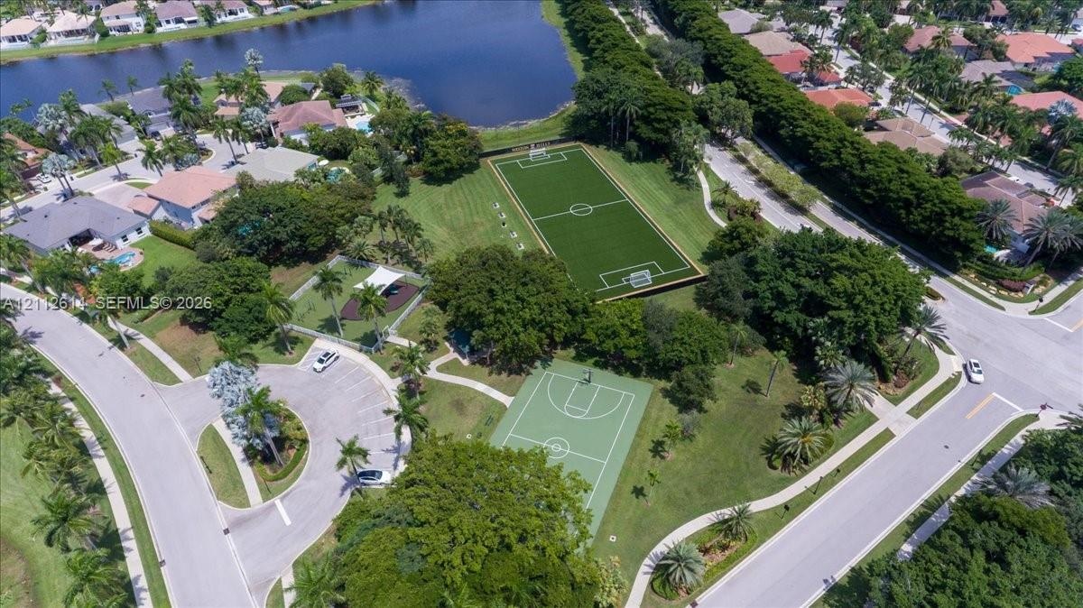Recreational area featuring a soccer field, basketball court, paved parking, and landscaped grounds