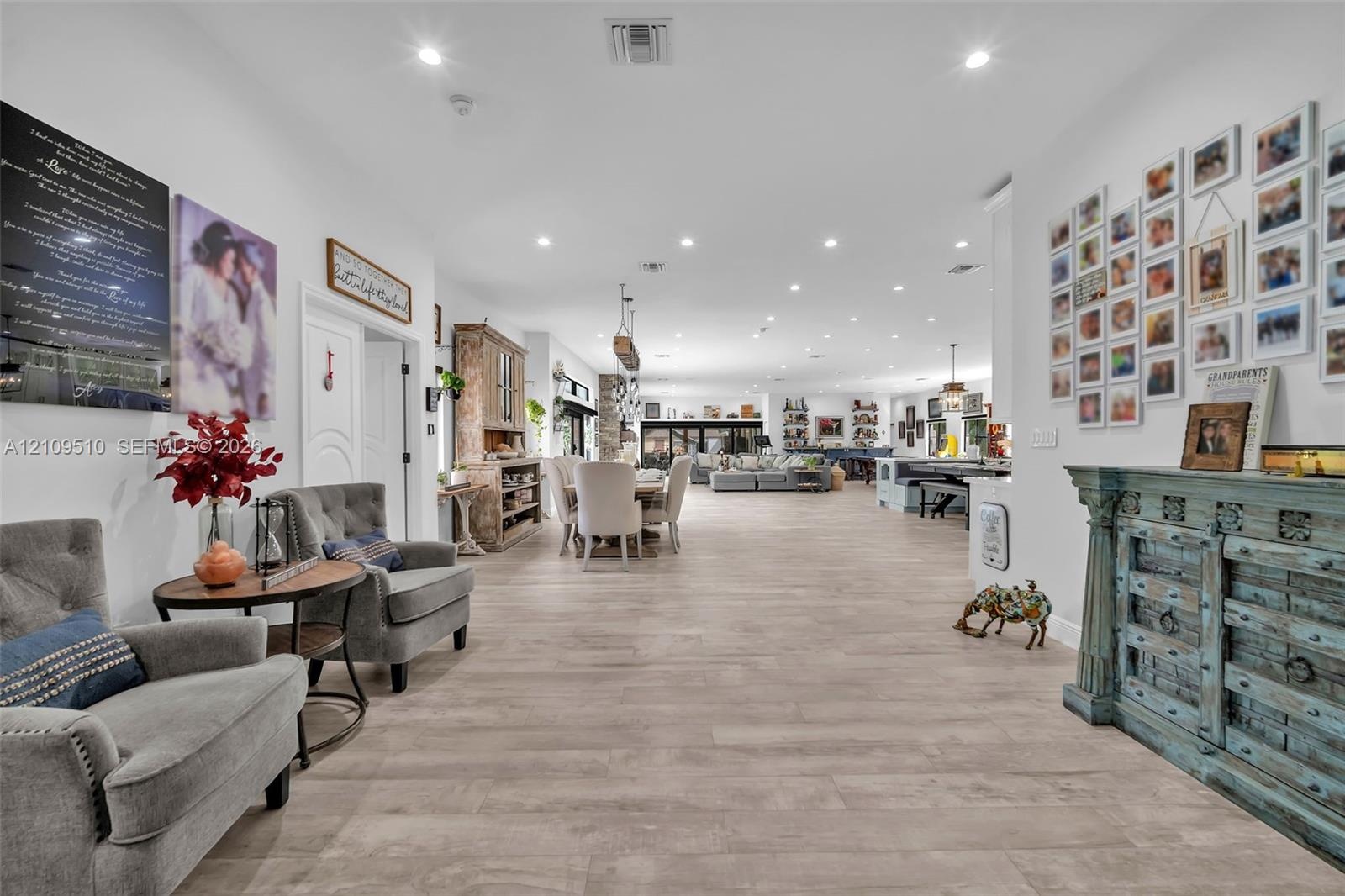 Open-concept interior featuring light wood-finish flooring, recessed lighting, and high ceilings
