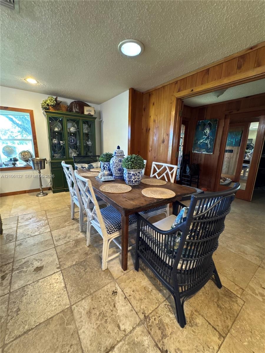 Tiled stone flooring, natural wood-paneled walls, and recessed ceiling lighting