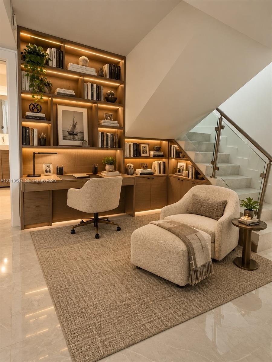 Custom built-in cabinetry featuring integrated LED shelf lighting and a coordinated workspace desk, complemented by a staircase with structural glass 