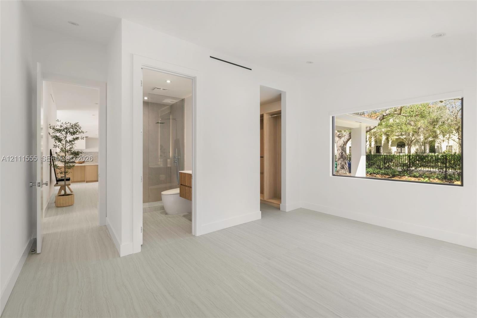 Interior room featuring wood-finish flooring, recessed lighting, expansive picture window, and built-in closet cabinetry