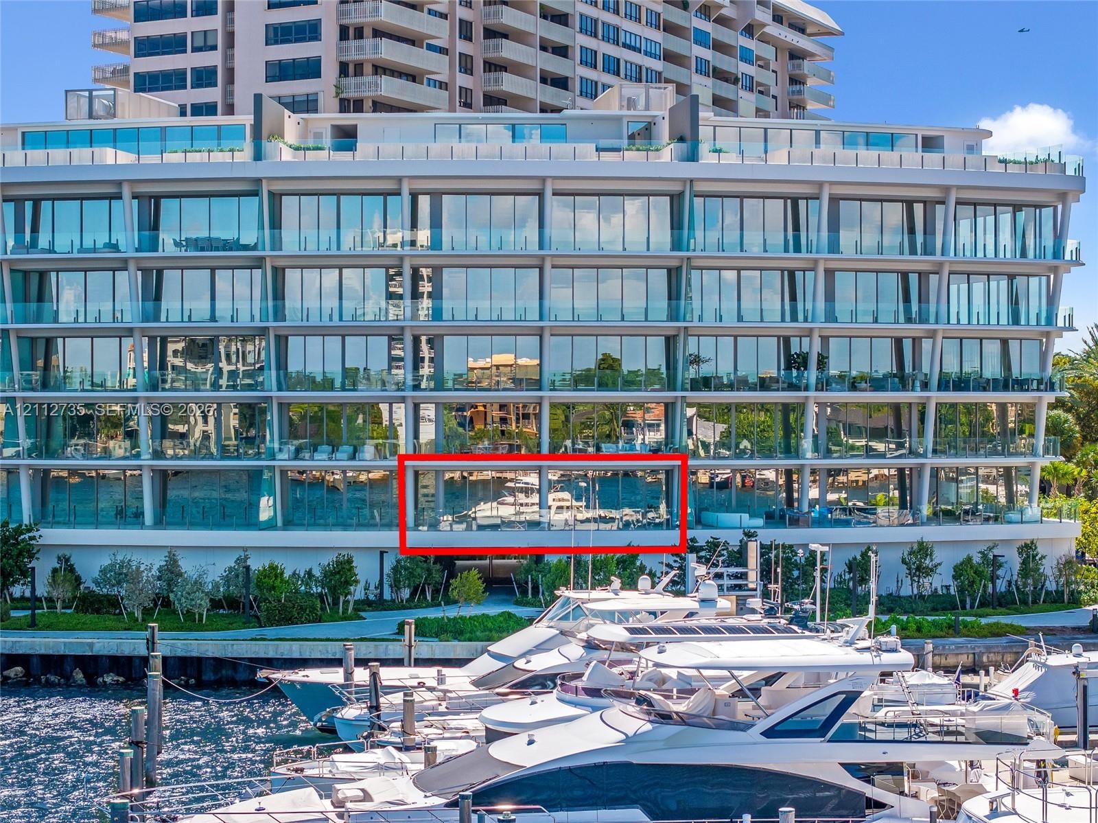Multi-story contemporary exterior featuring floor-to-ceiling glass paneling, horizontal cantilevered balconies with glass railings, and a deep-water m