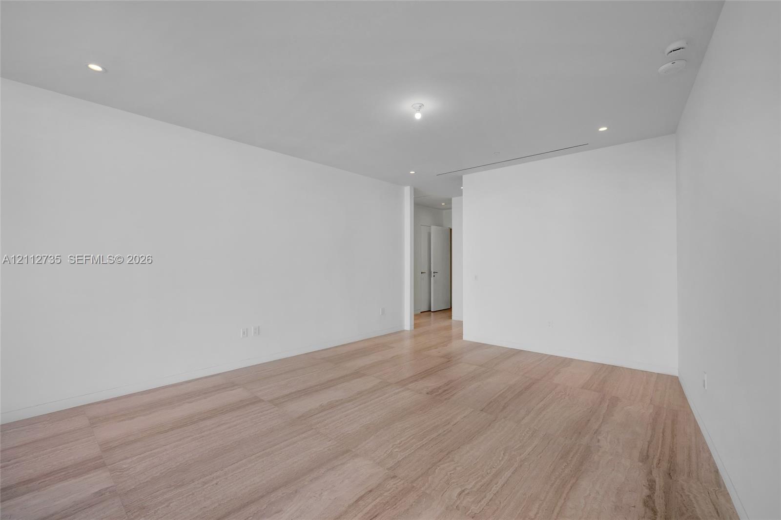 Minimalist interior featuring smooth walls, recessed ceiling lighting, and stone-finish flooring
