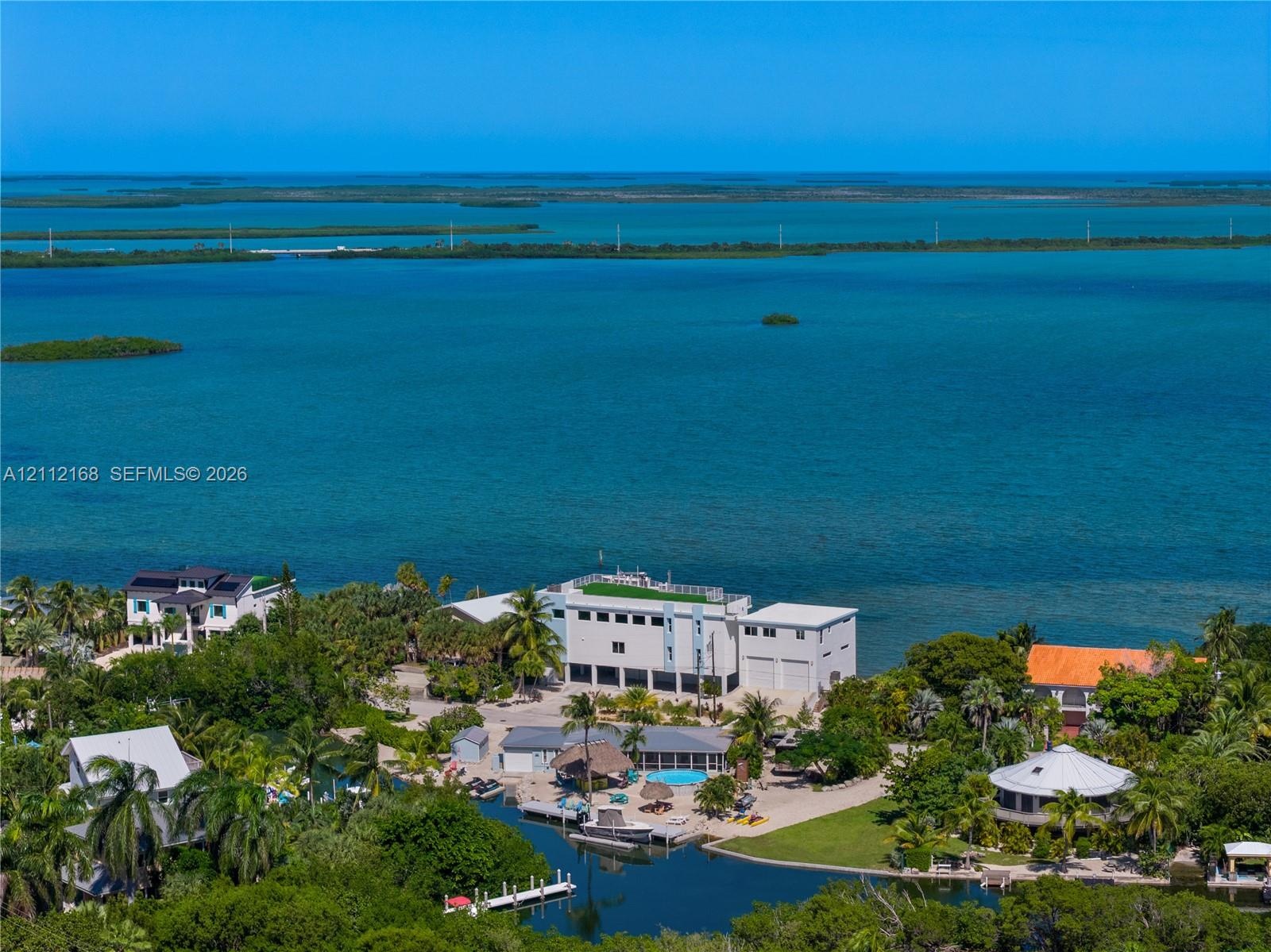 Waterfront property featuring a private boat dock, swimming pool, and direct canal access, situated on a lot with mature tropical landscaping