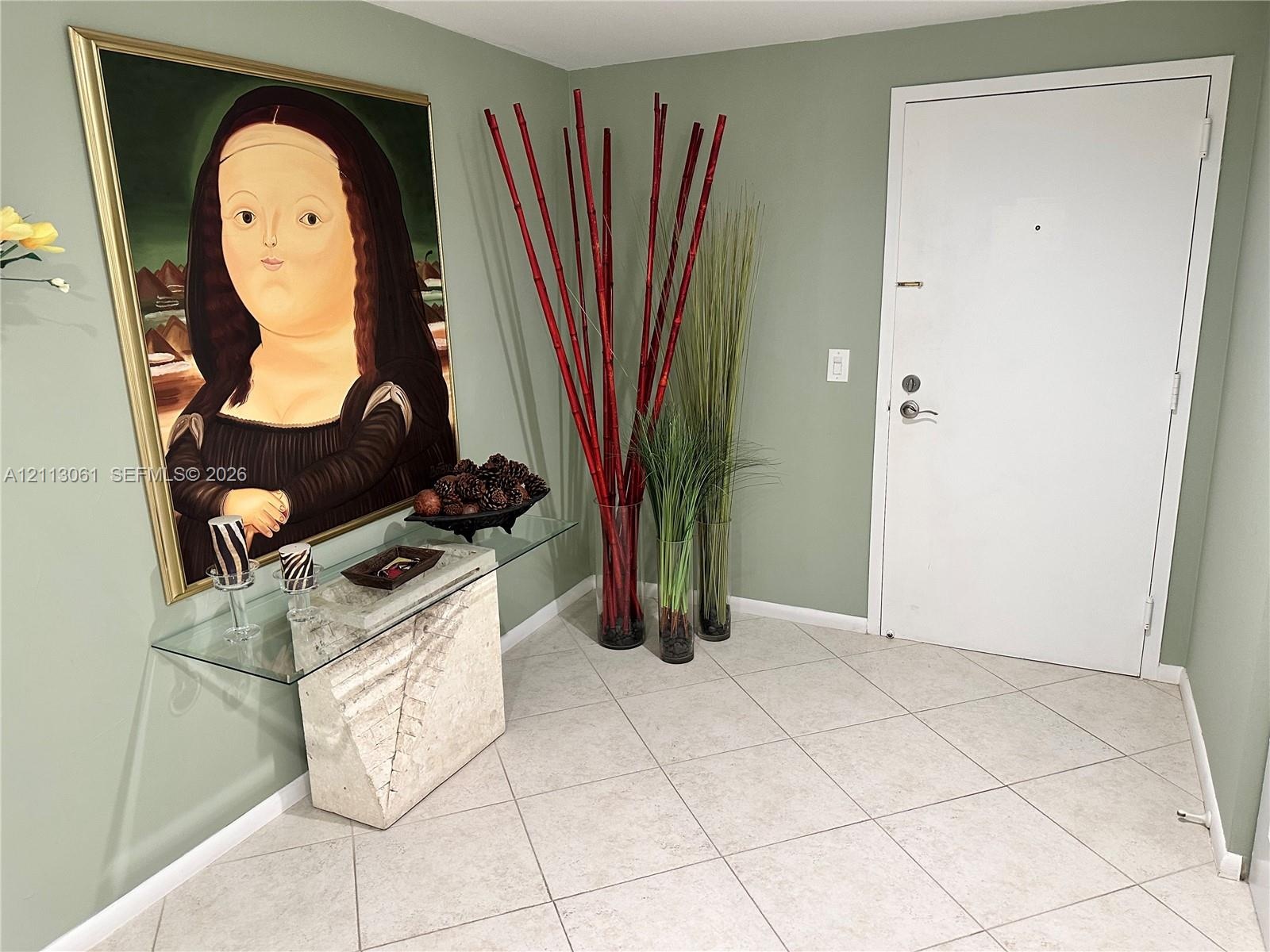 Entryway featuring light-colored diagonal floor tile and a solid-panel door
