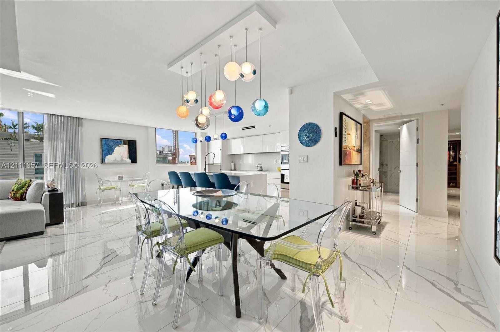 Large format tile flooring with high-gloss finish, multi-colored tiered glass globe chandelier, expansive floor-to-ceiling windows, and minimalist kit