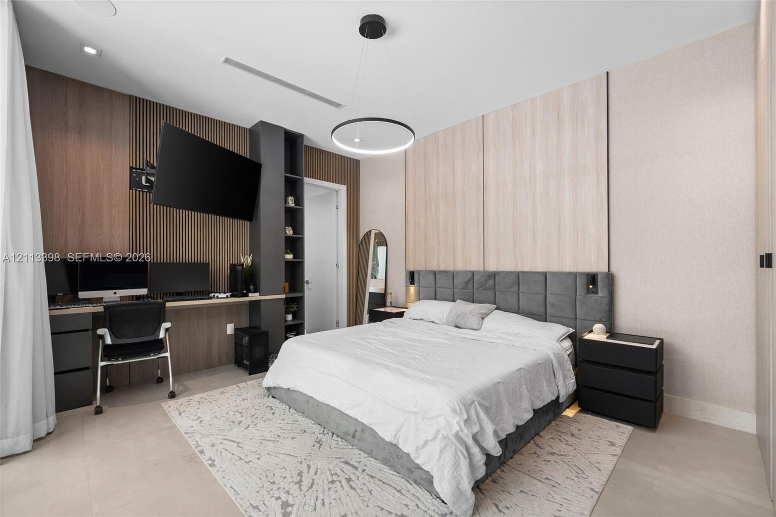 Custom built-in wood-slat desk station with integrated shelving, recessed ceiling lighting, circular pendant light fixture, and dual-tone wall panelin