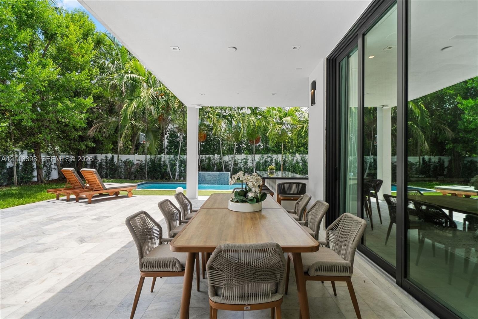 Covered patio featuring stone tile flooring, recessed ceiling lighting, and floor-to-ceiling sliding glass doors