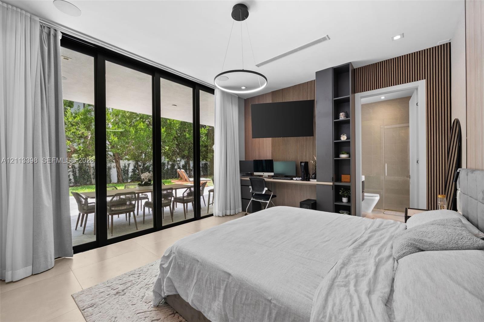Floor-to-ceiling sliding glass walls, custom wood-slat accent wall, built-in office cabinetry, neutral large-format tile flooring, and minimalist circ