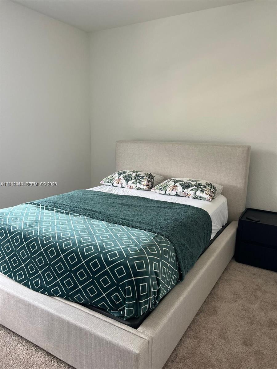 Neutral-toned interior space featuring light-colored wall paint and carpeted flooring