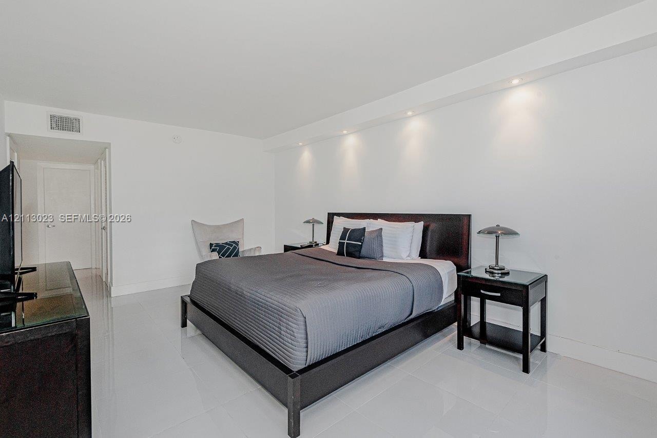 Spacious interior featuring glossy tile flooring, recessed ceiling lighting, and a neutral wall palette