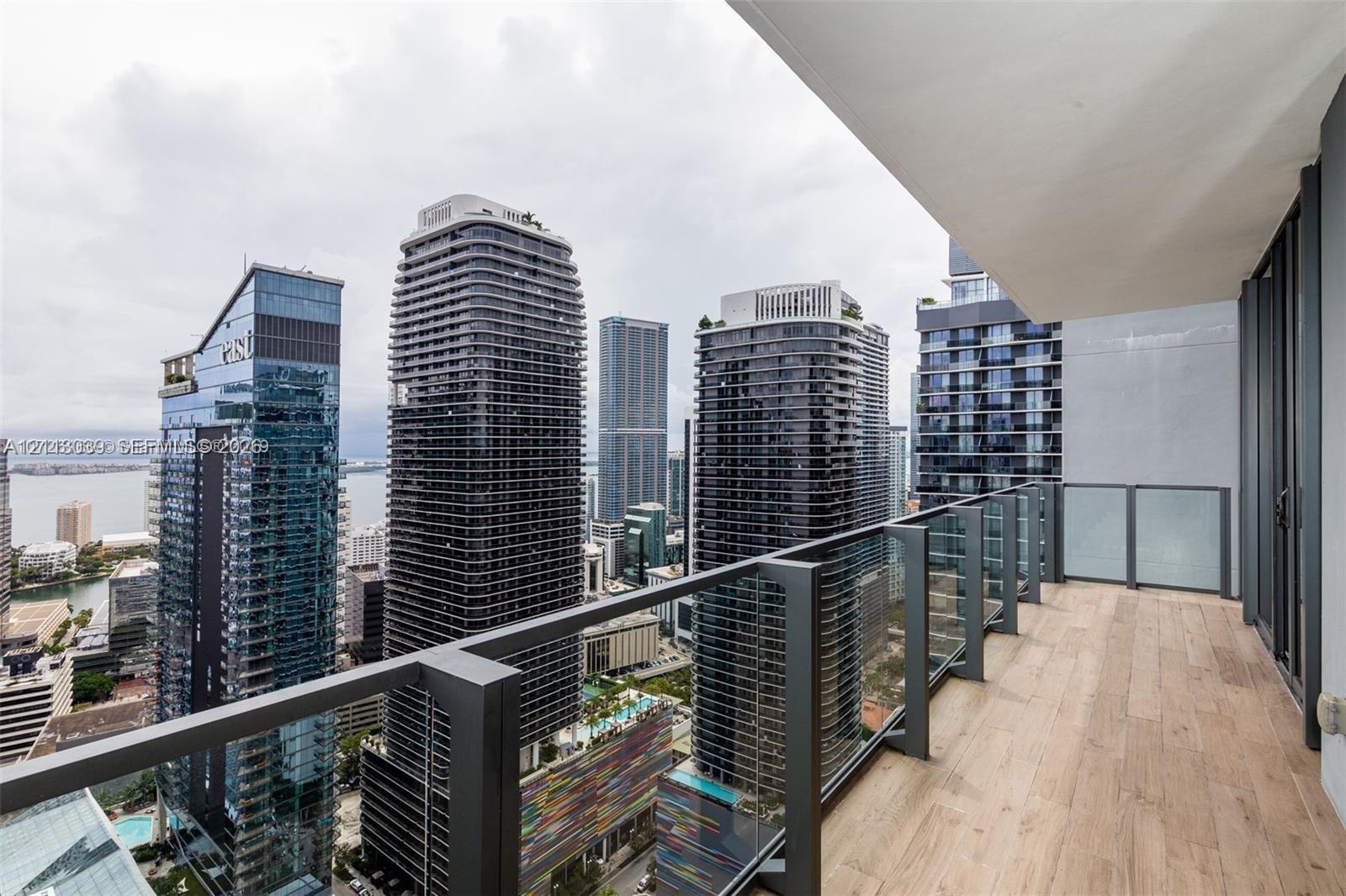 Private balcony featuring wood-finish flooring and a glass-panel railing with metal frame