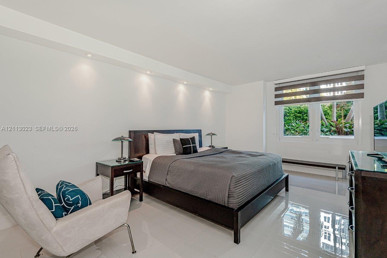 Neutral-toned tile flooring, recessed ceiling lighting, and horizontal shade window treatments
