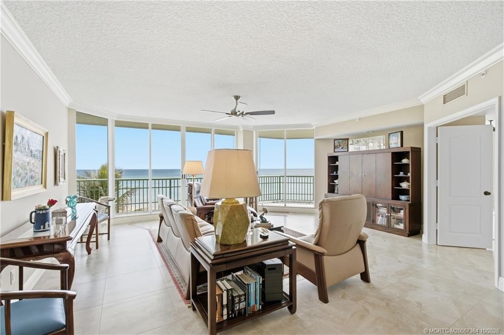 Bright, spacious living room featuring floor-to-ceiling glass and spectacular direct ocean views.