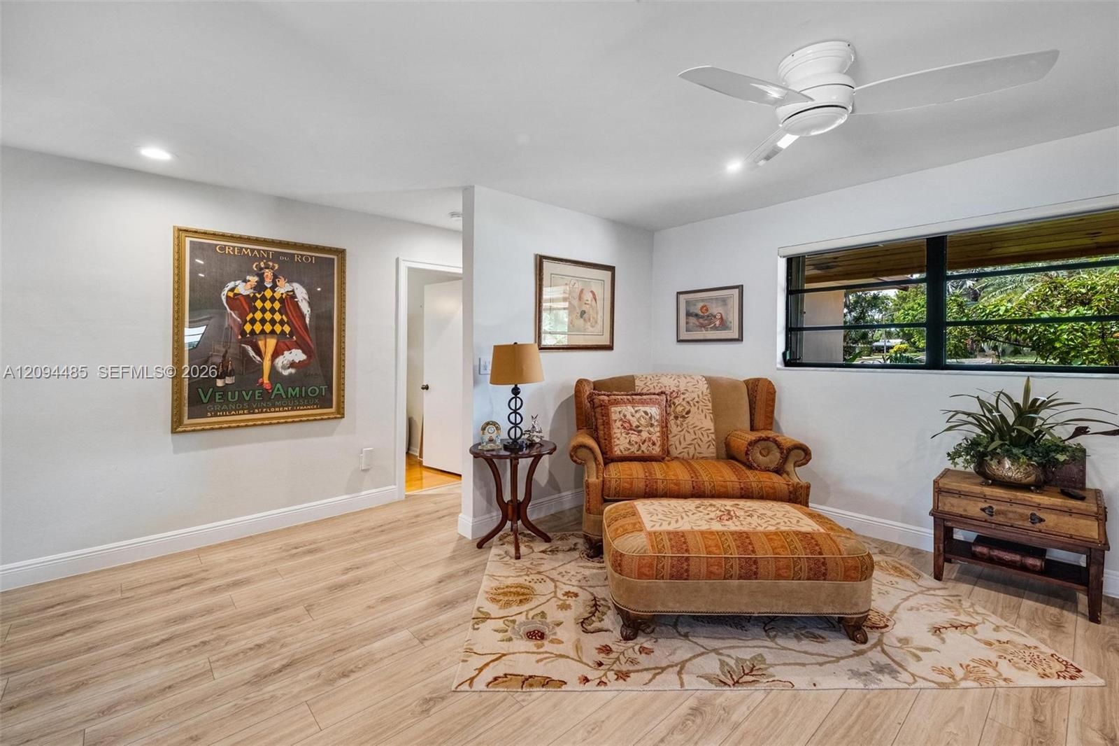 Light-toned wood-finish flooring, recessed lighting, white ceiling fan, and horizontal window with a black frame