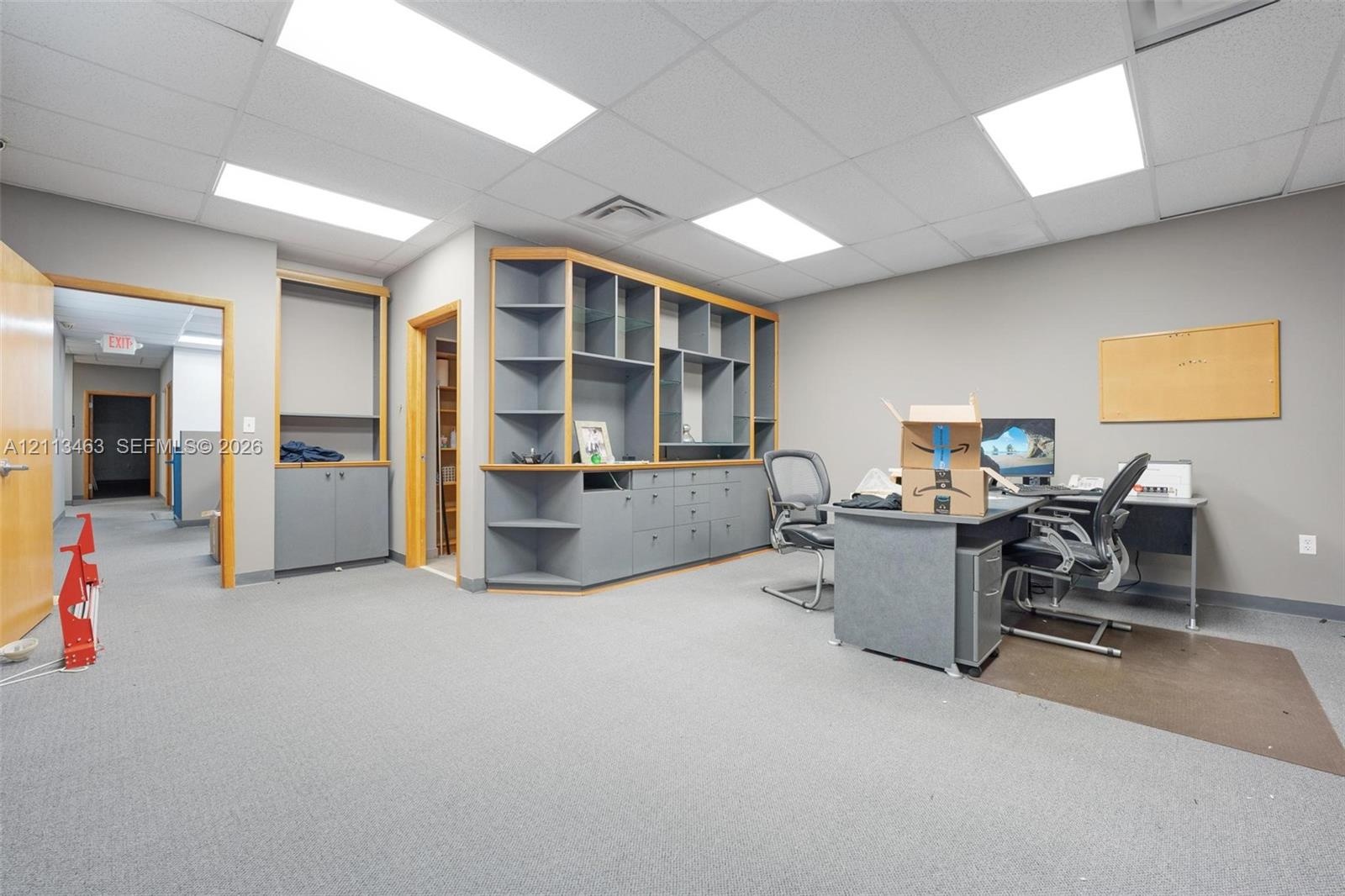 Interior office space featuring recessed ceiling lighting, wall-to-wall carpeting, and custom built-in cabinetry with integrated shelving