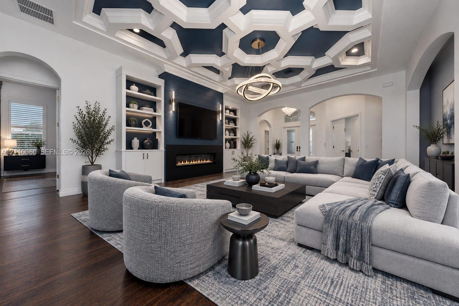 Virtually staged. Living area featuring an intricate geometric coffered ceiling, linear fireplace with a shiplap surround, built-in shelving, hardwood