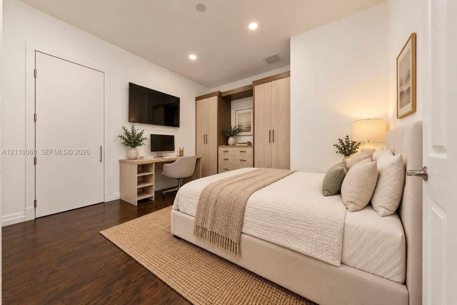 Virtually staged. Built-in light-tone wood cabinetry with integrated desk space, wood-finish flooring, and recessed ceiling lighting