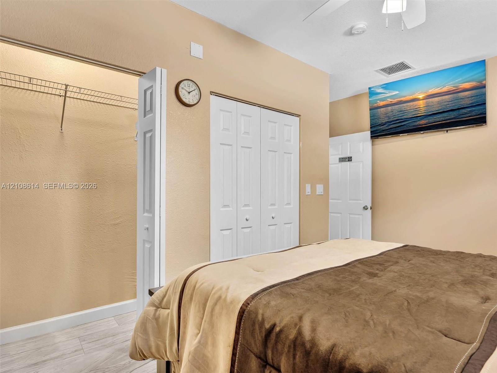 Interior space featuring wood-finish flooring, white bifold closet doors, and white multi-panel interior doors