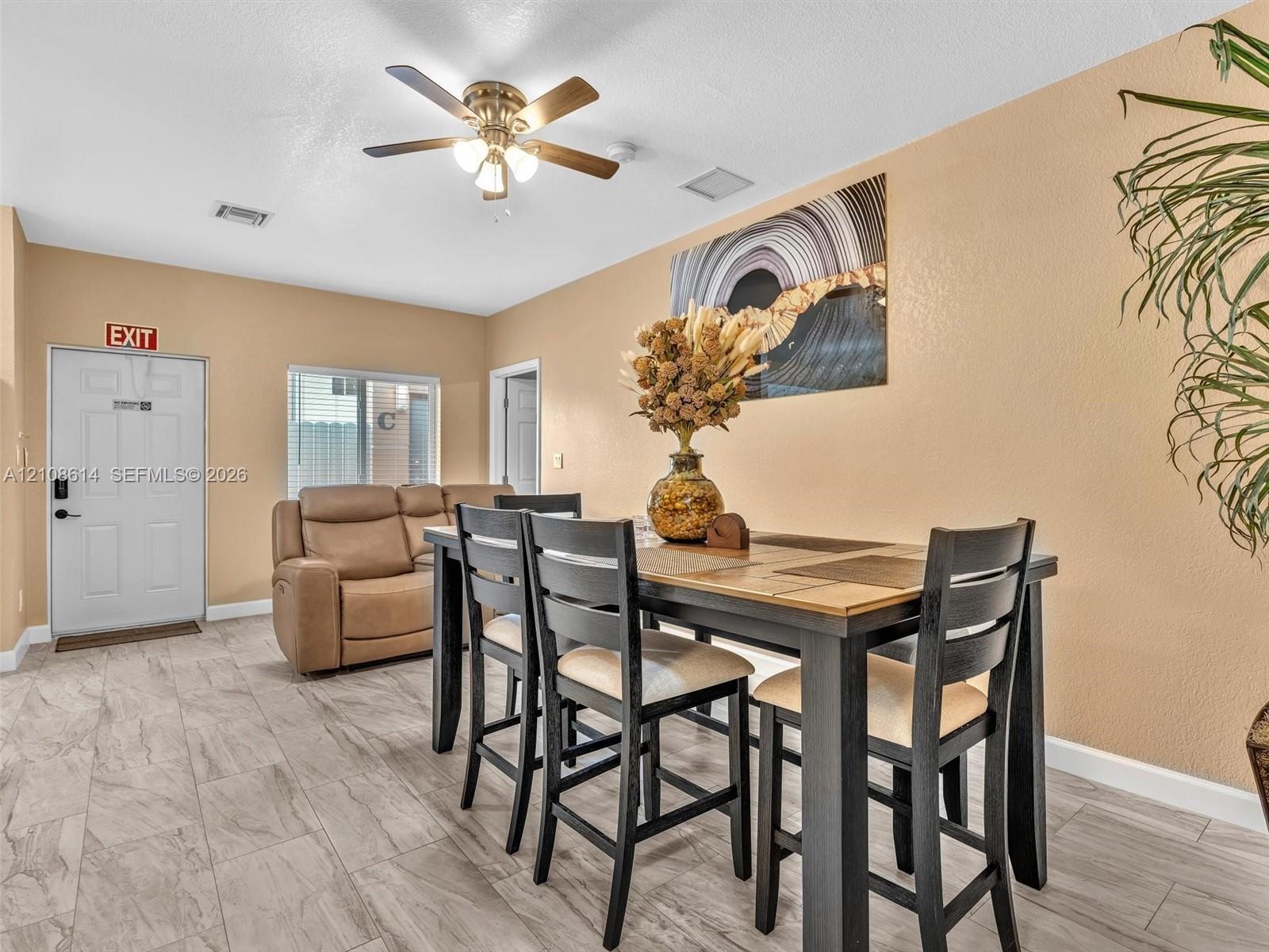 Ceramic tile flooring, neutral wall tones, and overhead ceiling fan with integrated lighting