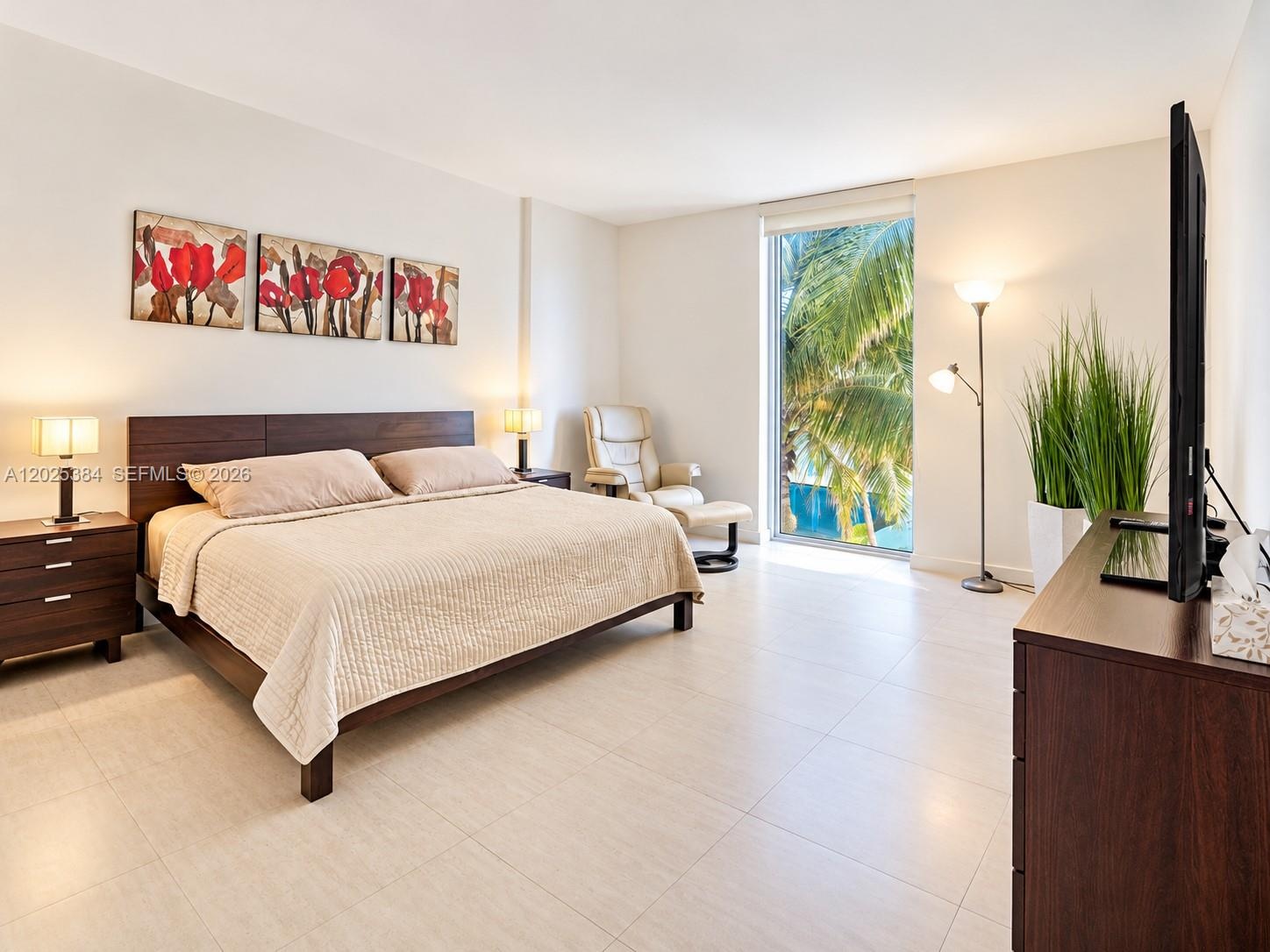 Spacious room featuring neutral tile flooring, floor-to-ceiling window, and natural illumination