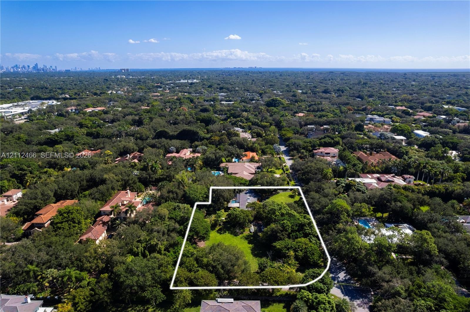 Aerial perspective of a sprawling lot featuring expansive green space and mature canopy trees