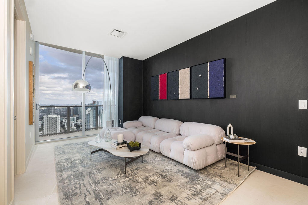 Floor-to-ceiling glass paneling featuring a metal frame and sliding glass door, providing a panoramic outlook, complemented by neutral tile flooring a