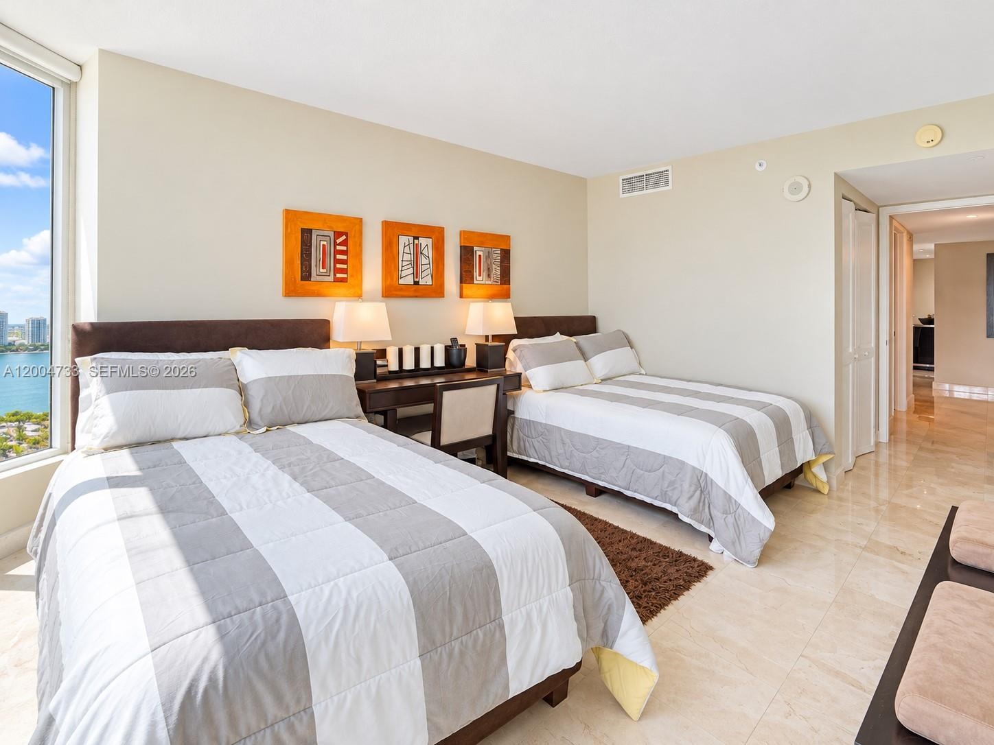 Floor-to-ceiling windows, polished stone-finish flooring, and crisp neutral wall paint