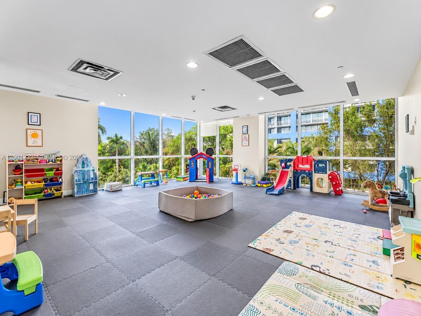 Open-concept room featuring floor-to-ceiling windows, recessed lighting, and interlocking foam flooring