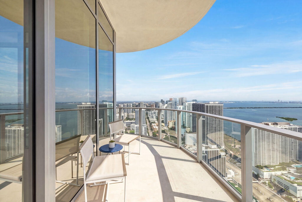 Curved balcony featuring floor-to-ceiling glass paneling and metal railings