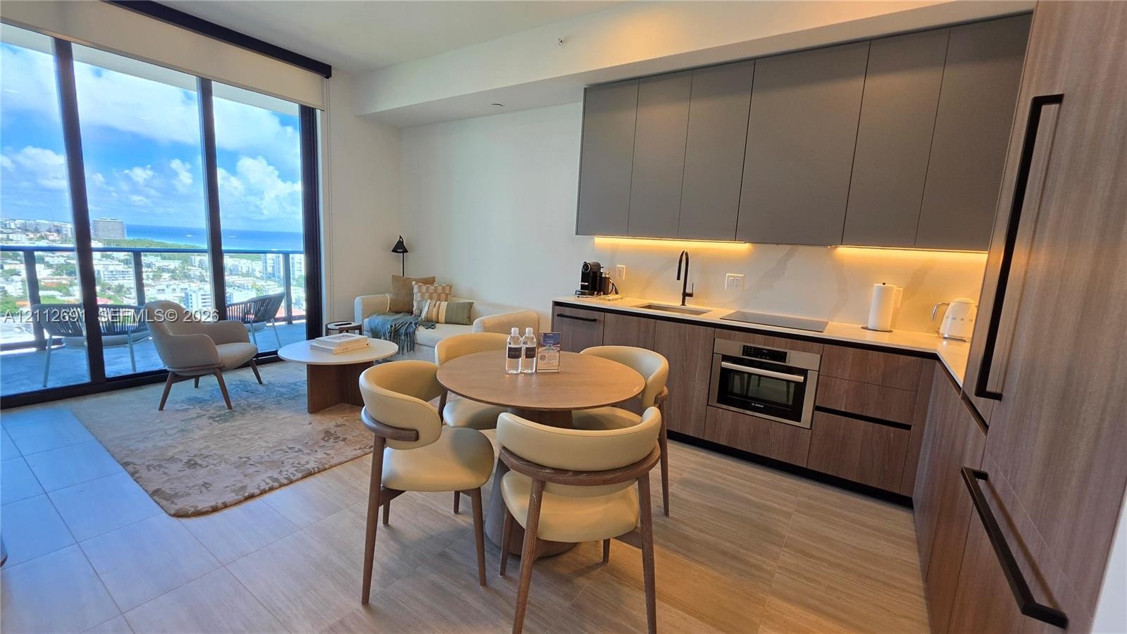 Contemporary kitchen featuring flat-panel two-tone cabinetry, stone-finish countertops with integrated backsplash, built-in wall oven and cooktop, woo