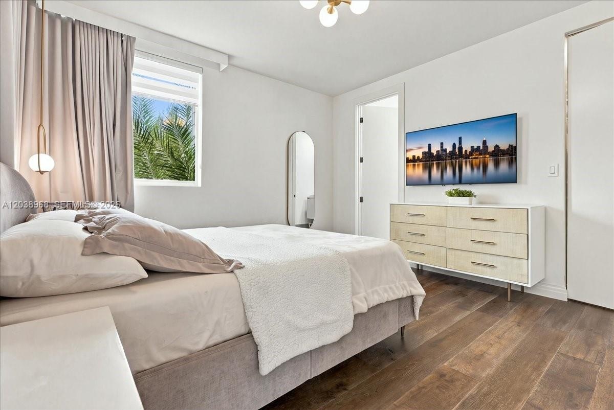 Wood-finish flooring, recessed lighting, polished metal hardware, and a modern multi-light chandelier fixture