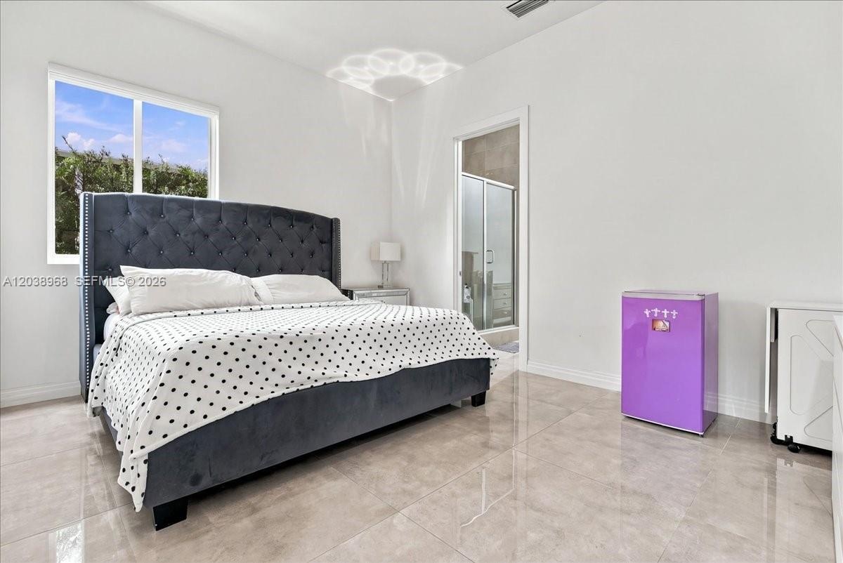 Neutral-toned polished tile flooring and recessed ceiling lighting within a bright, minimalist room featuring a large sliding window
