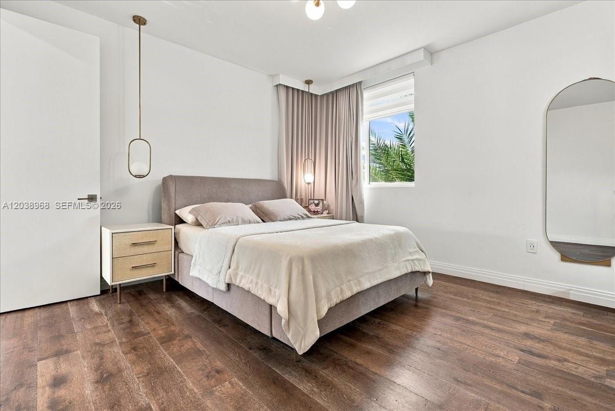 Wood-finish flooring, matte gold-tone pendant lighting, and a neutral color palette