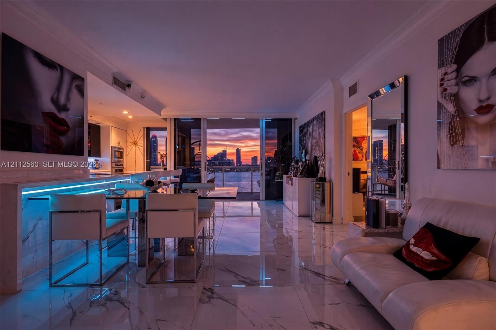 Open-concept living space featuring large-format polished stone-finish tile flooring, integrated linear LED accent lighting, and floor-to-ceiling slid