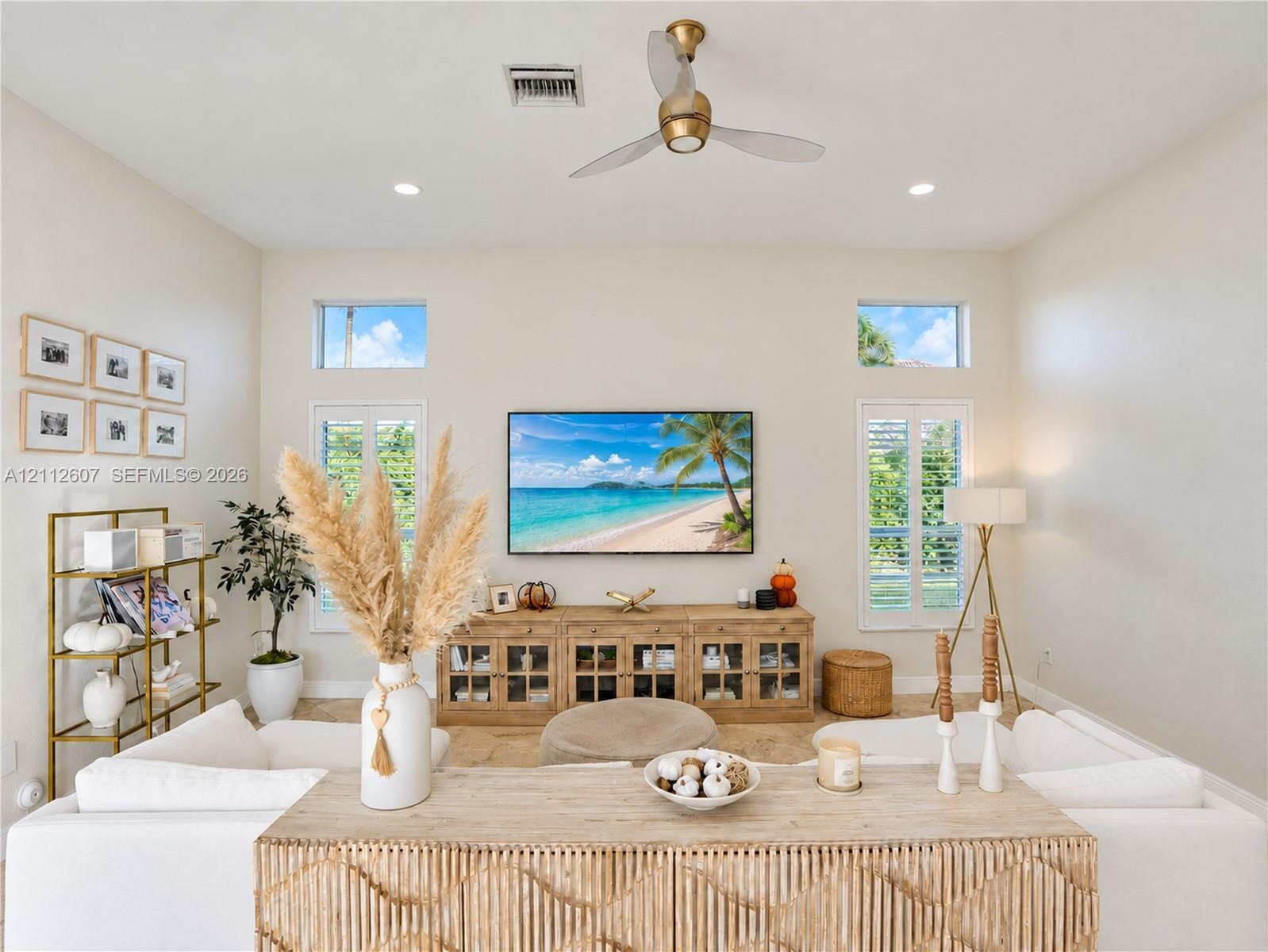 High ceilings featuring a central ceiling fan, neutral wall finishes, recessed lighting, double-hung windows with white shutters, and clerestory windo