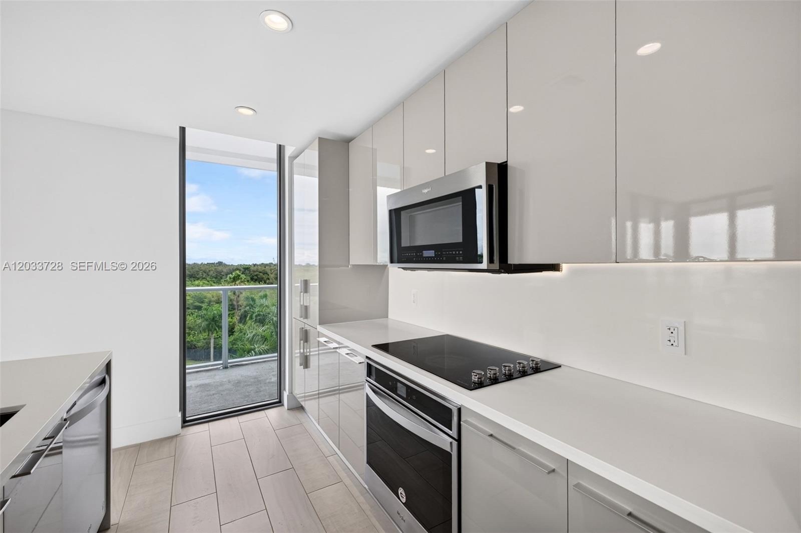 Neutral-toned tile flooring, dual floor-to-ceiling sliding glass doors, and recessed ceiling lighting