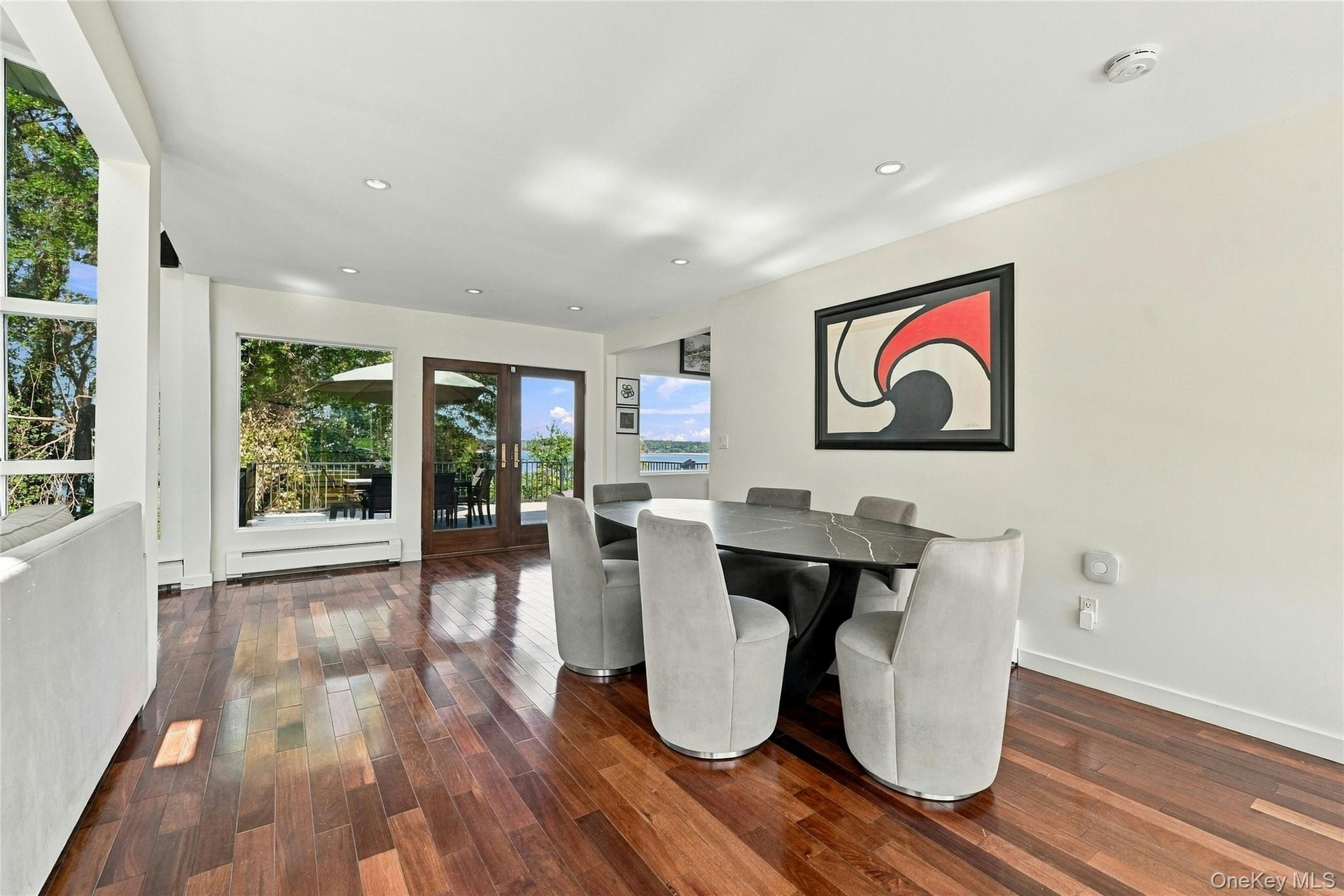 Dining room featuring hardwood flooring, recessed lighting, expansive glass windows, and glass-paneled double doors