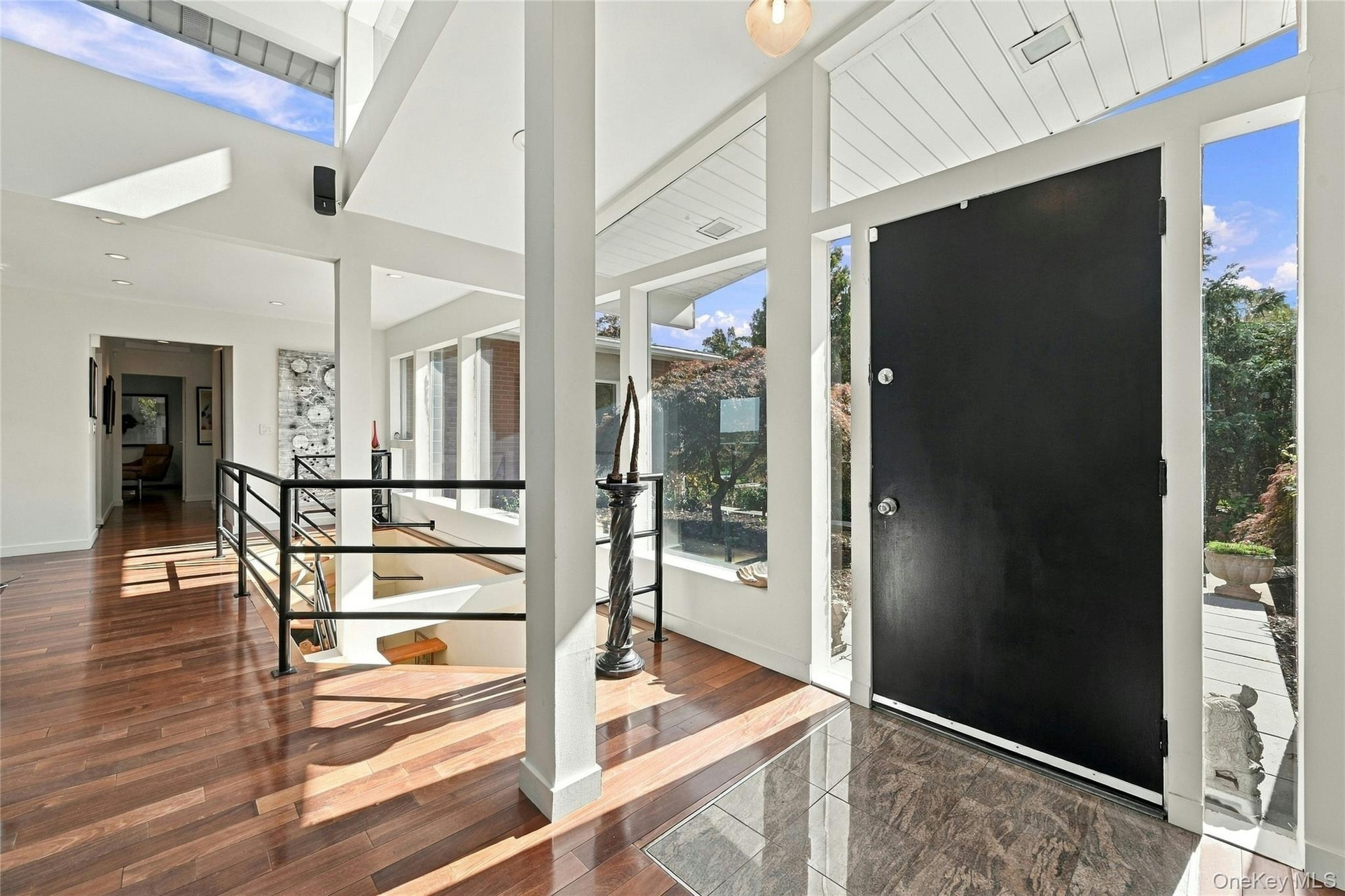 Entryway featuring Hardwood flooring, high ceilings, recessed lighting, and expansive floor-to-ceiling windows