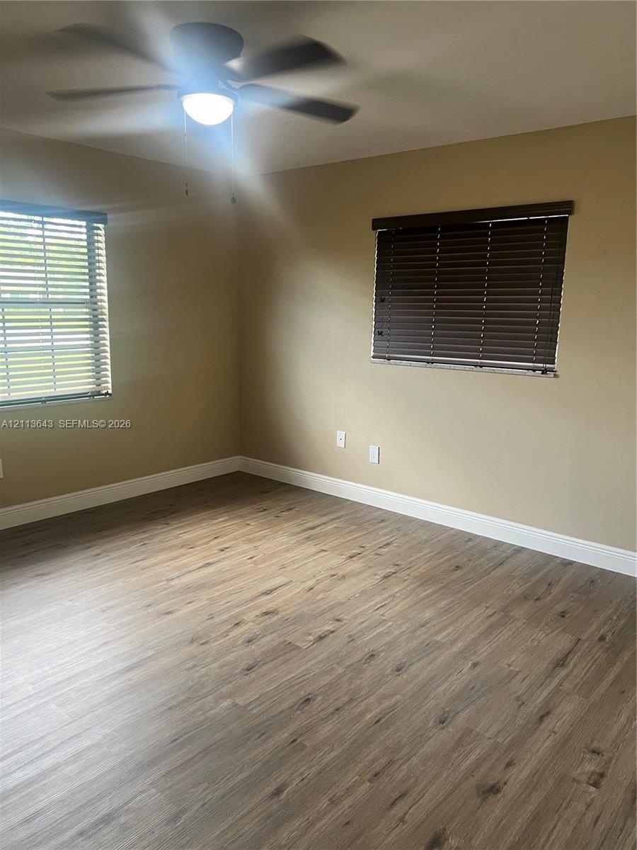 Wood-finish flooring, ceiling fan with integrated light fixture, and horizontal window blinds