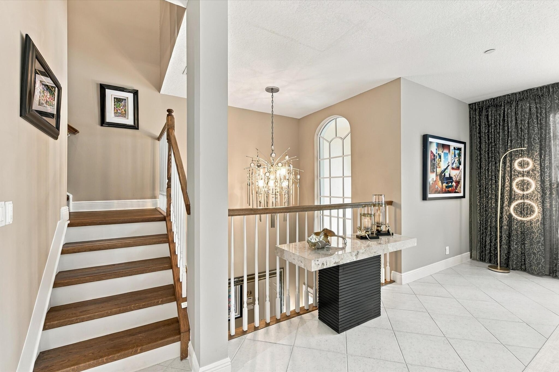 Staircase featuring wood-finish treads, white risers, and a wood handrail with white balusters