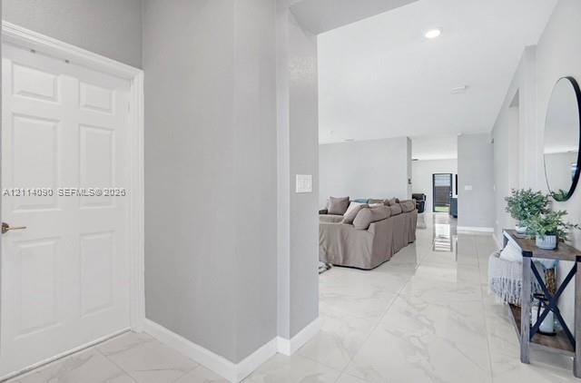 Entryway featuring large-format light-toned tile flooring, neutral wall paint, and recessed ceiling lighting