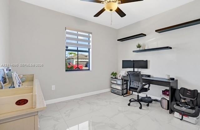 Room featuring large-format tile flooring, a central ceiling fan with an integrated light fixture, three mounted floating shelves, and a window equipp