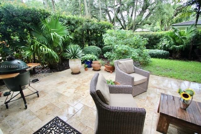 Stone paver patio featuring integrated landscaping with mature palm trees and manicured shrubbery