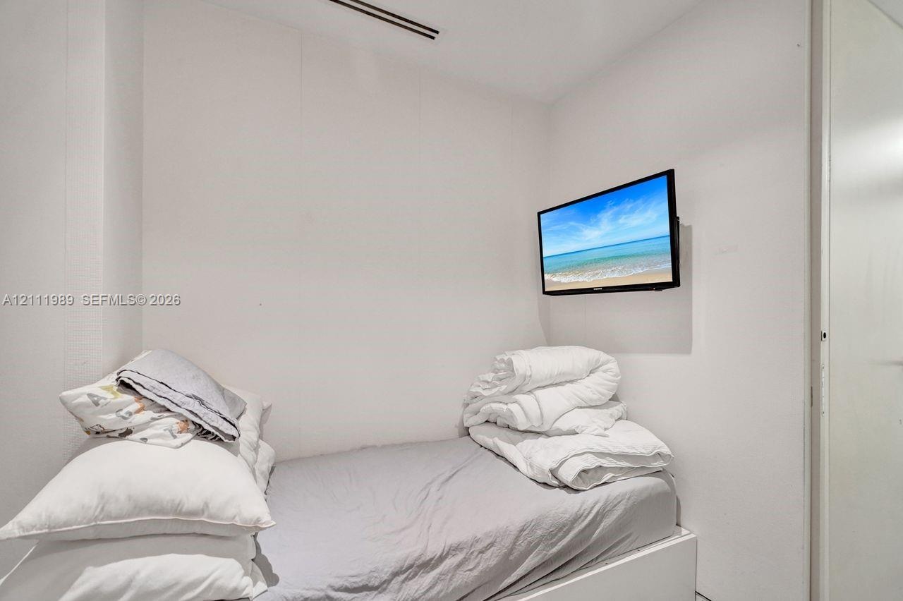 Wall-mounted flat-screen television and ceiling-mounted linear vent