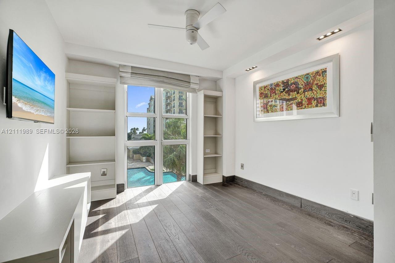 Wood-finish flooring, floor-to-ceiling windows, built-in shelving, ceiling fan, and recessed lighting