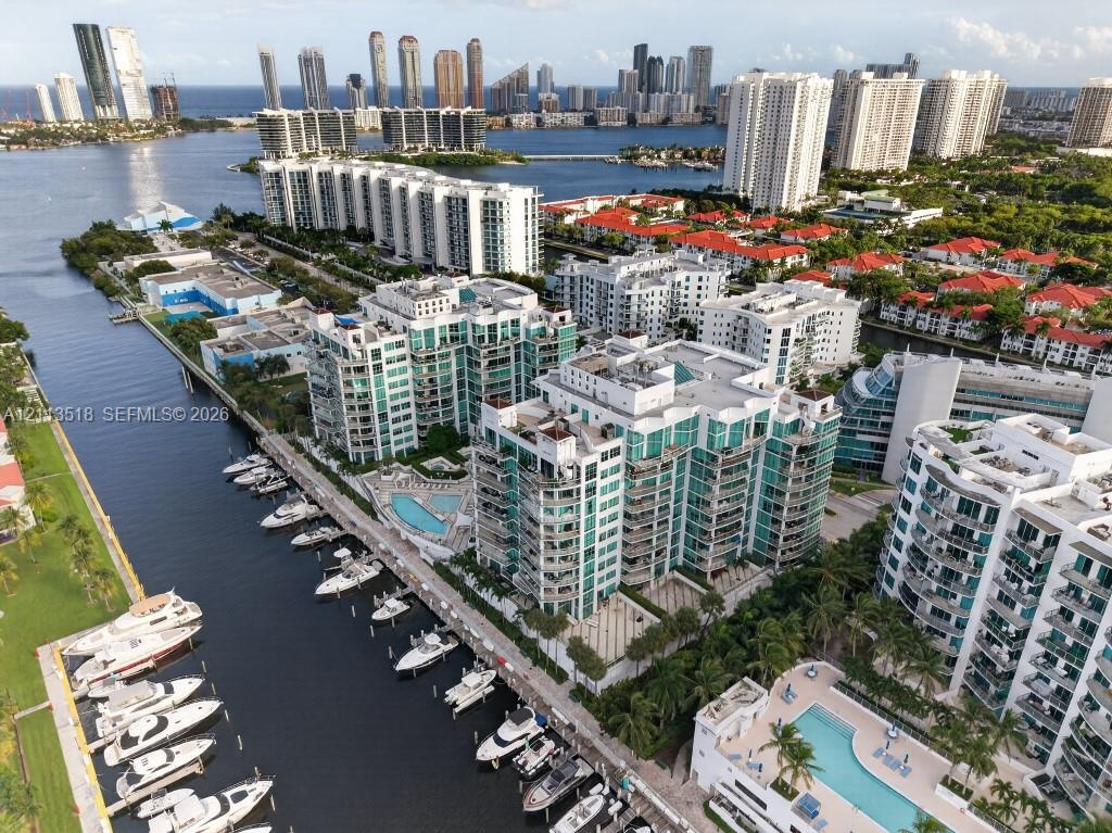 Waterfront high-rise condominium complex featuring a deep-water marina, multiple swimming pools, tiered architectural balconies, and proximity to the 