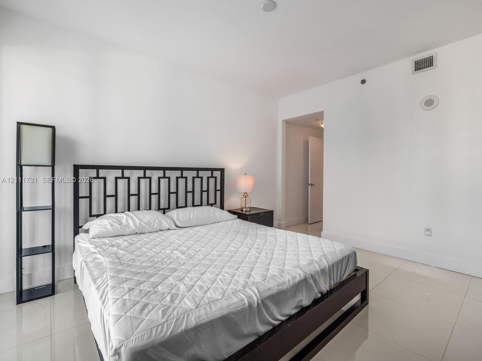 Neutral-toned interior space featuring light-colored polished tile flooring and crisp white wall finishes