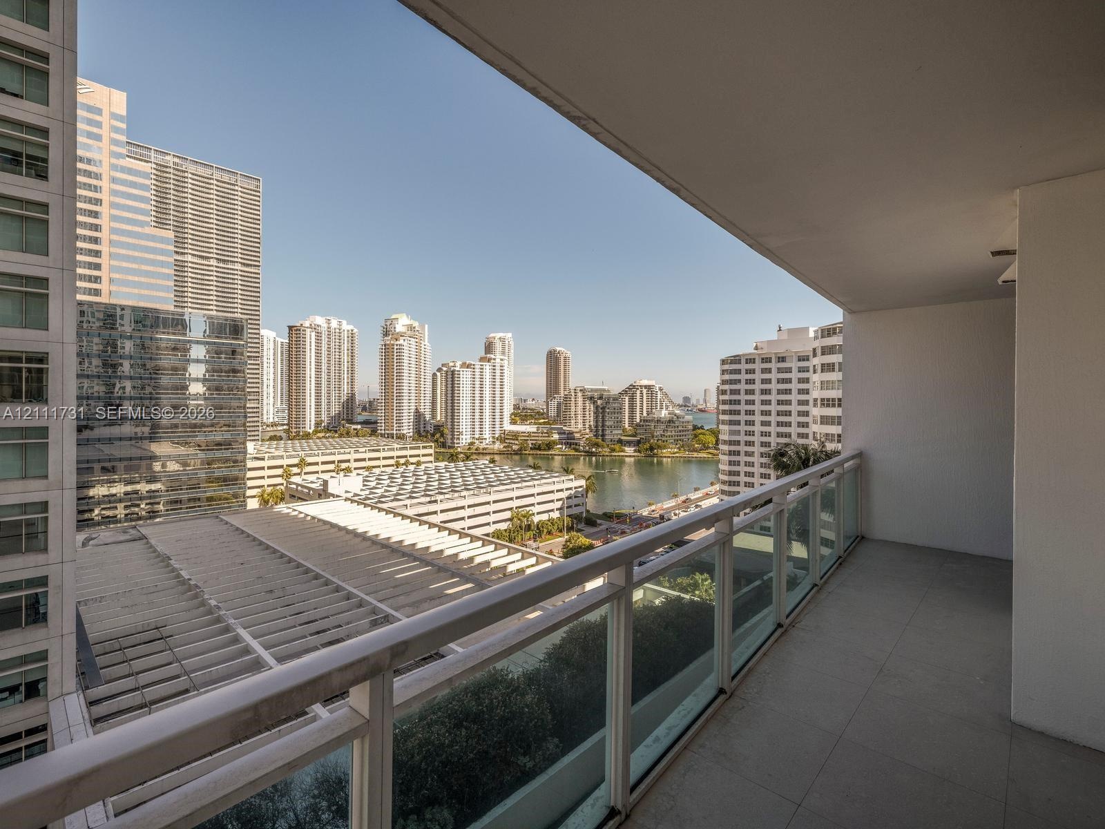 Covered balcony featuring tile flooring and a glass-paneled railing