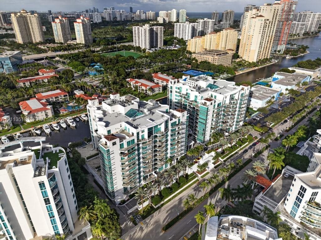 High-rise residential complex featuring glass-paneled balconies, multi-story structural design, dedicated marina slips, and extensive perimeter landsc